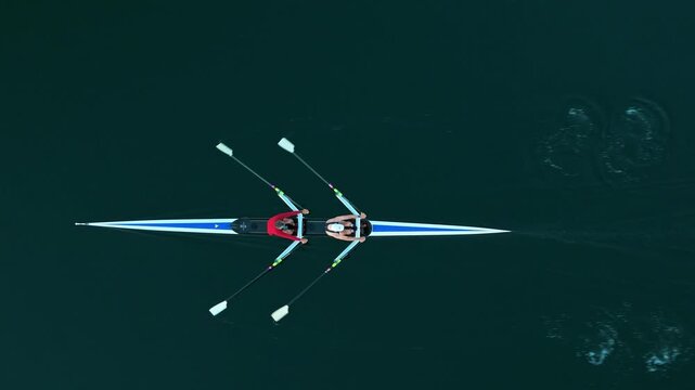 Top View Two skilled men navigate a sleek rowing boat in the stunning waters of Halifax Ocean Bay, showcasing teamwork and athleticism. Aerial view captures the beauty of training in Nova Scotia