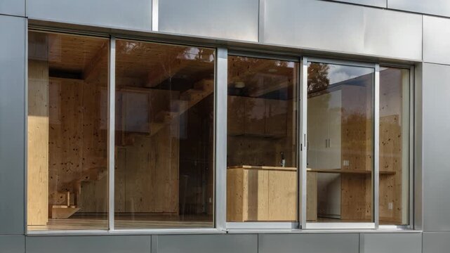 Elegant silver metal cladding frames natural wood interiors in medium shot highlighting both modern design and energyefficient window technology.