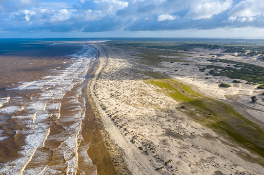 Aerial view of Mambrui Sand Dunes Dubai Ndogo featuring rolling white sand dunes meeting the turquoise ocean under a dramatic cloudy sky Malindi, Kilifi County, Kenya.