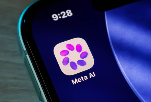 Closeup of the meta ai app icon on a smartphone screen, showcasing the colorful, circular logo design against a dark blue background