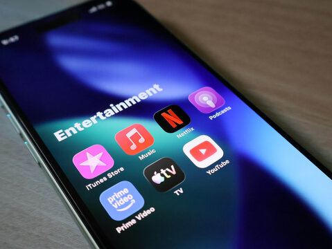 Closeup of a iPhone screen displaying an entertainment folder with various popular streaming and media application icons