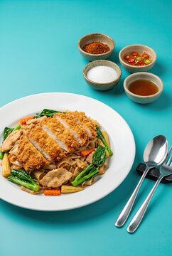 Generated AI set photos Thai stir-fried noodles Pad See Ew topped with crispy fried chicken cutlet and fresh vegetables