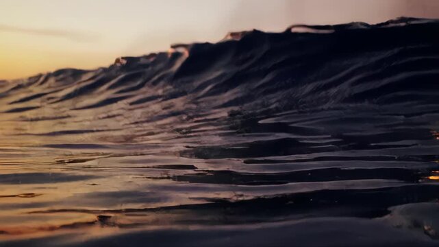 Abstract textured dark waves under a soft gradient sunset or sunrise sky