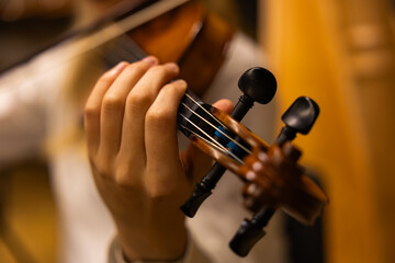 Close up of child hand playing violin during classical orchestra concert © Ruslan
