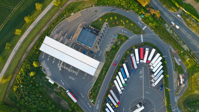 Aerial view of Rugby Services motorway service station with parked trucks and green fields in Rugby, England, United Kingdom.