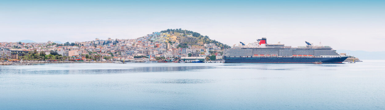 Cruise ship docked at Kusadasi port on the Aegean Sea, with the Turkish city and hills providing a scenic panoramic view