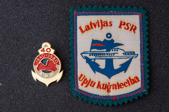 Latvian river shipping company vintage fabric patch and enamel anchor badge memorabilia. Vintage SSR embroidered fabric patch with an anchor and ship. Kyiv, Ukraine - May 24, 2026