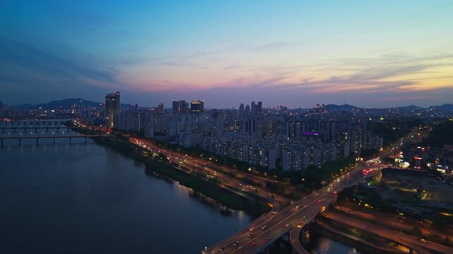 Aerial panorama of night Seoul skyline with busy traffic on bridges and Gangbyeonbuk-ro Expressway in Gwangjin District at twilight in South Korea