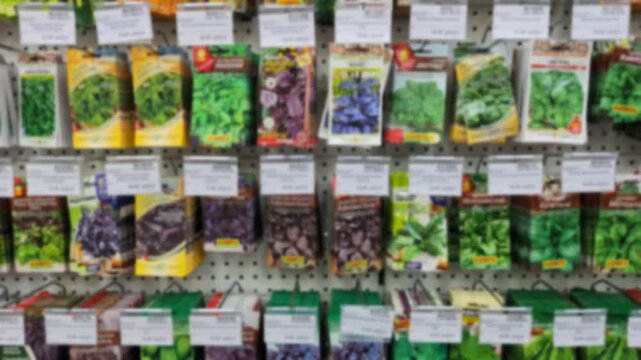 Various seed packets hanging on a pegboard shelf in a retail store. The image shows multiple types of seeds in colorful packaging arranged in rows.
