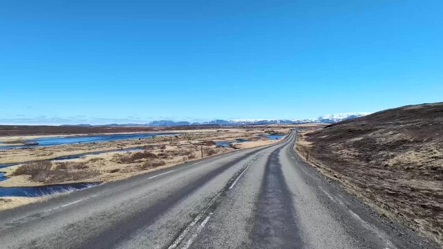 Conduite sur une route islandaise entre rivi&egrave;re, montagnes et grands espaces naturels