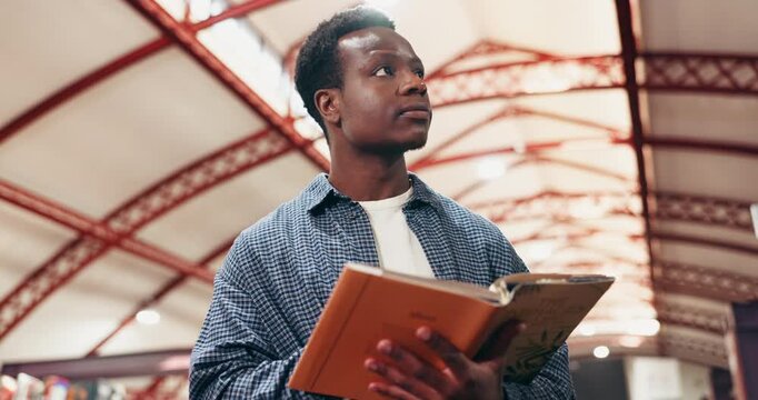 Reading, university and black man with book in library for education, learning or research with knowledge. Study, project and African male student with academic information for college exam on campus
