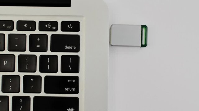 Detail of a USB drive next to a laptop, representing portable technology and fast data transfer.
