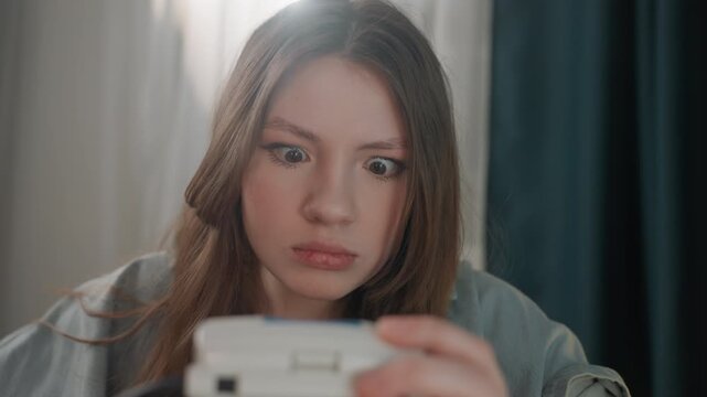 Caucasian woman reacting to monitor reading with shocked expression in soft bedroom light, worried patient moment, office worker role and solo check scenario, closeup emotion and tense gaze