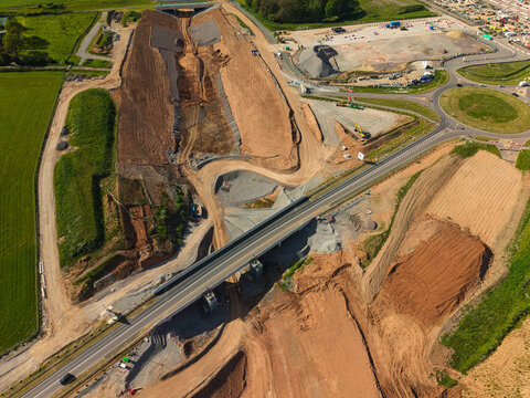 Aerial view of HS2 High Speed Rail Civil Engineering Works featuring extensive earthworks and a new road bridge over the construction site in Kenilworth, England, United Kingdom.