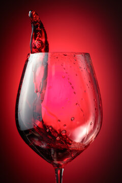 Wine glass with red liquid frozen in movement.