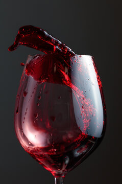 Wine glass with red liquid frozen in movement.