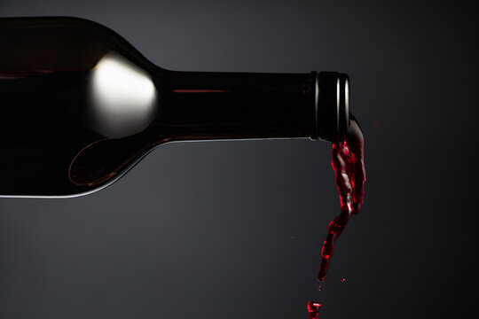 Red wine pours out of the bottle.