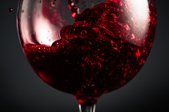 Red wine of rich dark color being poured into a glass.