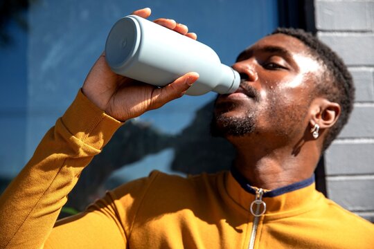 Man drinking from reusable bottle.
