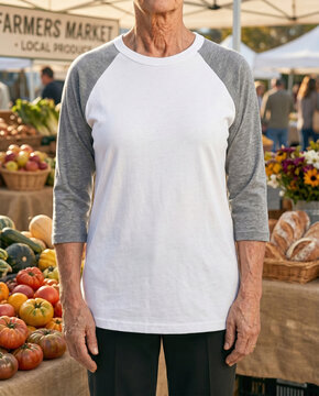 Outdoor portrait of man wearing blank white and grey raglan baseball t-shirt mockup, apparel template at farmers market with blurred background