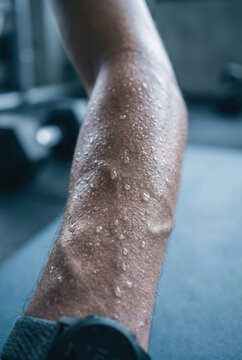 Sweaty athletic arm close up wet skin with water drops vascular veins muscular hand fitness workout training gym concept