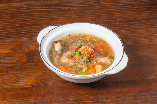 Authentic Indonesian sop buntut oxtail soup with hearty vegetables and aromatic broth, traditional Asian cuisine served in rustic style