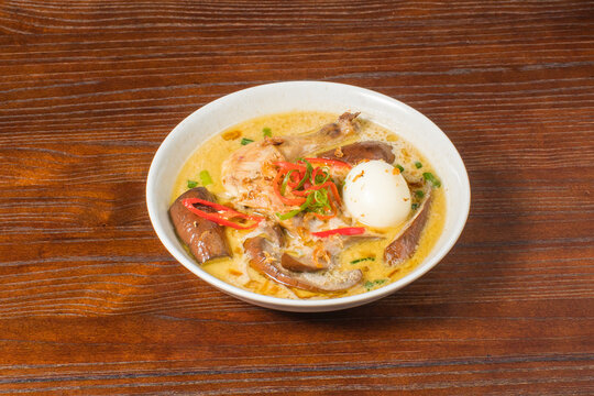 Traditional Indonesian mangut ayam served in creamy coconut broth with egg and chili topping, authentic local cuisine with rich savory flavor
