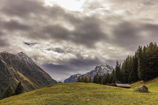 Dark clouds over an alpine meadow above Grimentz, in the background the mountain peaks of Corne de Sorebois and Scex Marenda, Val d'Anniviers, Valais Alps, Canton Valais, Switzerland