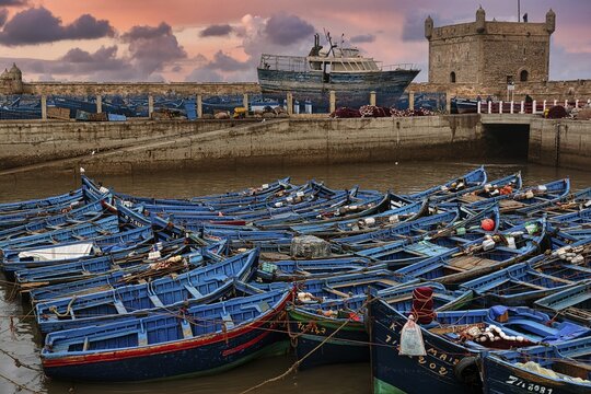 Traditional blue fishing boats in the fishing port, evening sky, Essaouira, Morocco