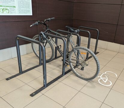 Aparcamiento de bicicletas en el interior de una terminal de autobuses con el s&iacute;mbolo blanco de bicicleta en el suelo, con una bicicleta de monta&ntilde;a Rockrider. Madrid, Espa&ntilde;a, 21 de abril de 2026