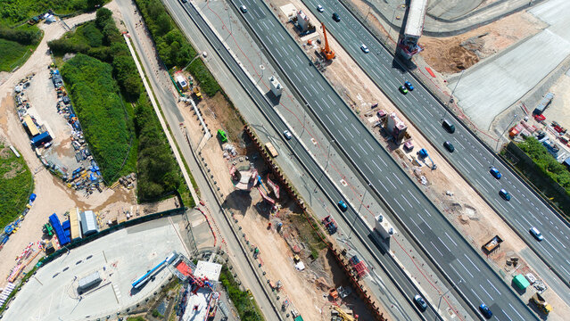 Aerial view of the HS2 Project construction site featuring heavy machinery and earthworks alongside a busy motorway in Coleshill, England, United Kingdom.