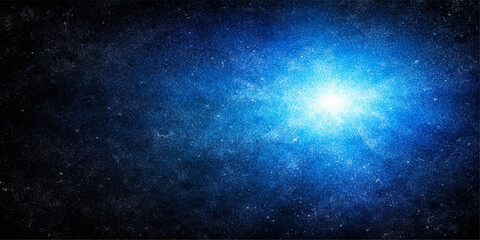 An abstract dark blue cosmos background featuring a bright galaxy nebula and shiny stars in the deep outer space universe © Kazim