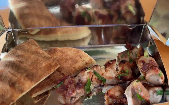 Pork souvlaki for delivery. Greek fast food - pita with grilled meat, takeout. Greek cuisine - vegetables and meat.