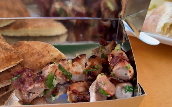 Pork souvlaki for delivery. Greek fast food - pita with grilled meat, takeout. Greek cuisine - vegetables and meat.