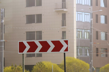 Obraz premium Red directional arrows guiding drivers in an urban area