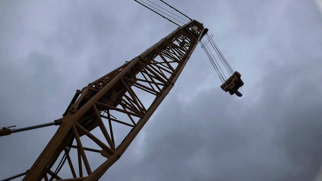 Tower crane jib seen from below against a cloudy sky
