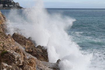 Fototapeta premium A wave splashes against coastal rocks in the South of France