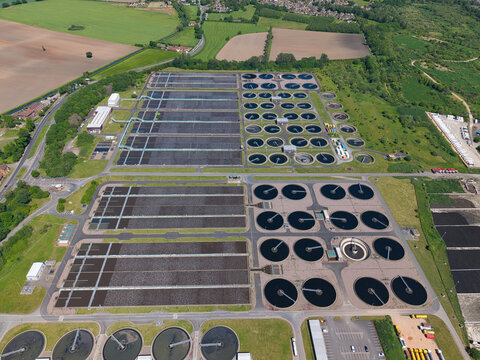 Aerial view of the Severn Trent Water Minworth treatment plant with circular sedimentation tanks and rectangular filtration beds in Birmingham, England, United Kingdom.