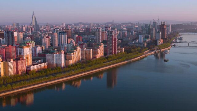 Panoramic view of Pyongyang from Yanggakdo Hotel. Taedong River in morning fog. Ryugyong Hotel and modern residential complex upstream. Atmospheric, calm, iconic. Pyongyang, North Korea