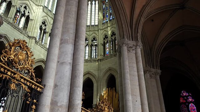 Sunlight inside Amiens Cathedral with gothic columns and ornate religious decor