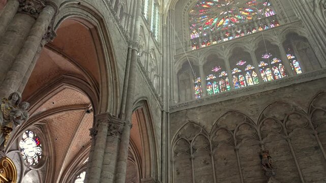 Interior of Amiens Cathedral with gothic arches stone columns and rose windows