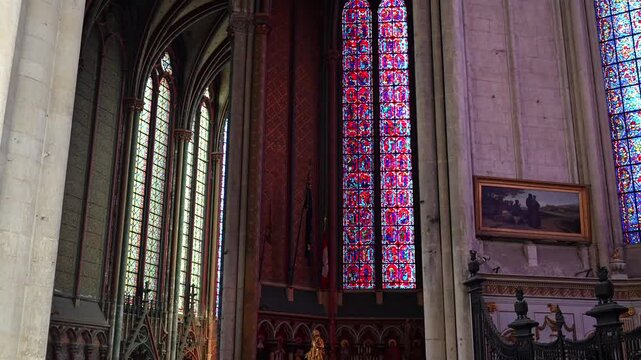 Colorful stained glass windows with gothic tracery inside Amiens Cathedral
