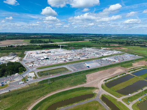 Aerial view of the HS2 Concrete Segment Manufacturing and Production Site with industrial cranes and concrete structures surrounded by green fields Birmingham, England, United Kingdom.