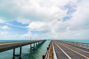 Obraz premium Bridge road with bicycle lane oversea. Iconic famous seven mile bridge between Marathon and Little Duck Key. Seven mile bridge in Florida keys. Oversea highway in Miami. Travel destination