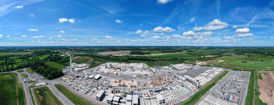 Aerial view of the HS2 Concrete Segment Manufacturing and Production Site with industrial machinery and stacked concrete components under a blue sky in Birmingham, England, United Kingdom.