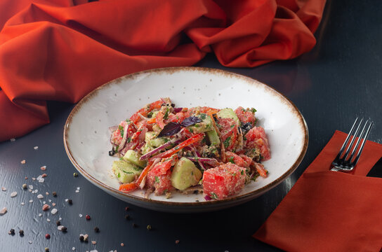 Juicy salad with fresh tomatoes, cucumbers and onions On a dark background. Menu for a Georgian restaurant.