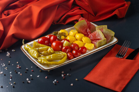 appetizers set pickles, cabbage and tomatoes on a plate, Fermented vegetables on plate sauerkraut On a dark background. Menu for a Georgian restaurant