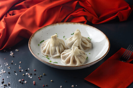 Georgian dumplings Khinkali with meat, greens On a dark background. Menu for a Georgian restaurant. Restaurant menu