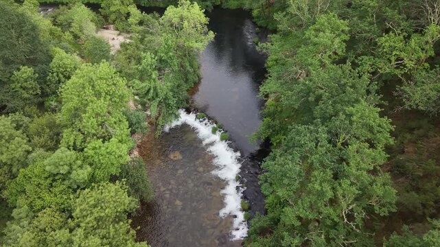 Rio lerez river flowing over rocks surrounded by lush green trees and vegetation