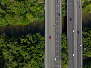 Motorway bridge with traffic crossing the river aerial top down view. Beautiful lush green environment with trees by the river Medway. Light traffic on M20 motorway in Kent, UK. © Ssisabal